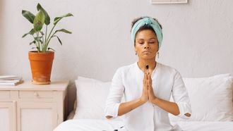 vrouw mediteert op bed