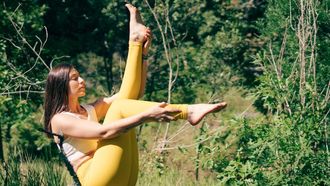 vrouw doet yoga in natuur