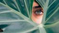 introverte vrouw kijkt door bladeren