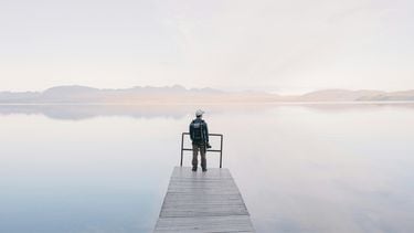 fotograaf kijkt uit over water foggy