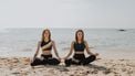 Women doing yoga on the beach