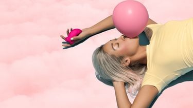 vrouw blaast een bel van kauwgom hen heeft seksspeeltje in de hand