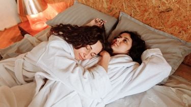 Wat is een open relatie? Twee personen knuffelen in bed