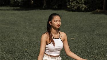 vrouw mediteert in gras