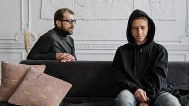 foto van een vader en zoon die naar elkaar kijken