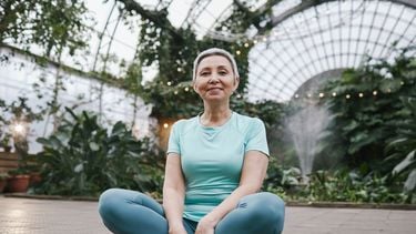 Vrouw zittend op yoga mat