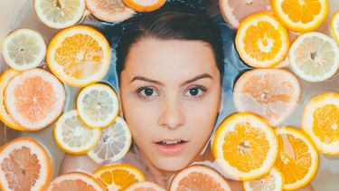 vrouw in bad met citrusvruchten