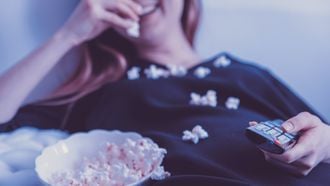 Vrouw die popcorn eet