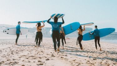 groepsles surfen op strand