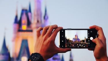 Persoon die foto maakt van kasteel in Disneyland met telefoon