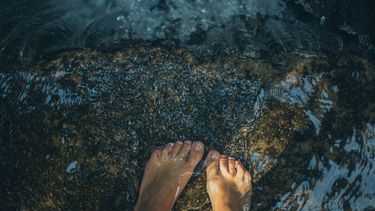 voeten met grote teen in het water