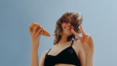 Meisje met pizza in haar hand