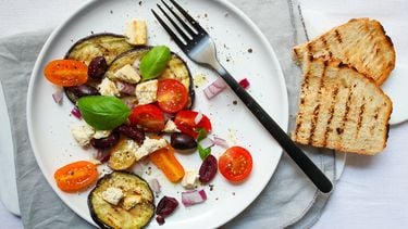 bord met tomaat, aubergine en olijven salade
