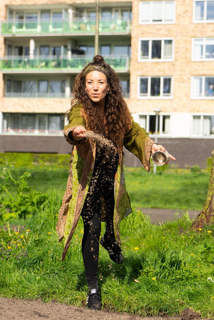 Tosca van der Wouden strooit bloemzaad uit.