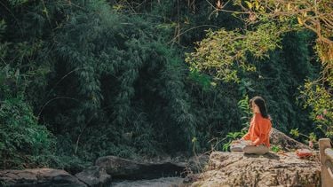 vrouw mediteert in de natuur