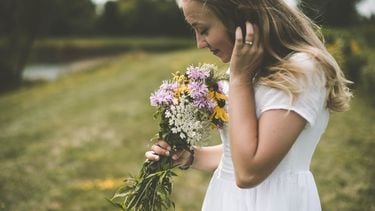 meisje ruikt aan bloemen